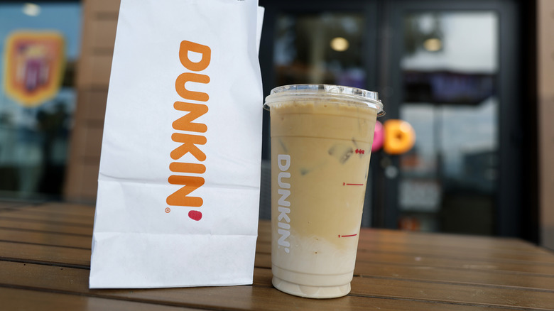 Dunkin' coffee next to bag on table