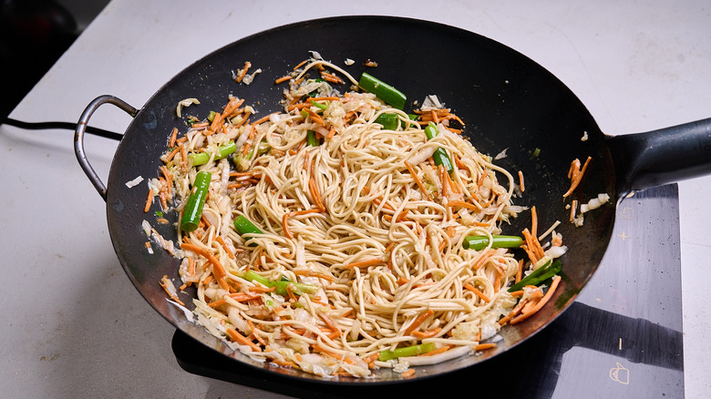 lo mein with vegetables in wok