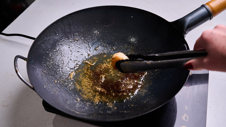removing shrimp from wok