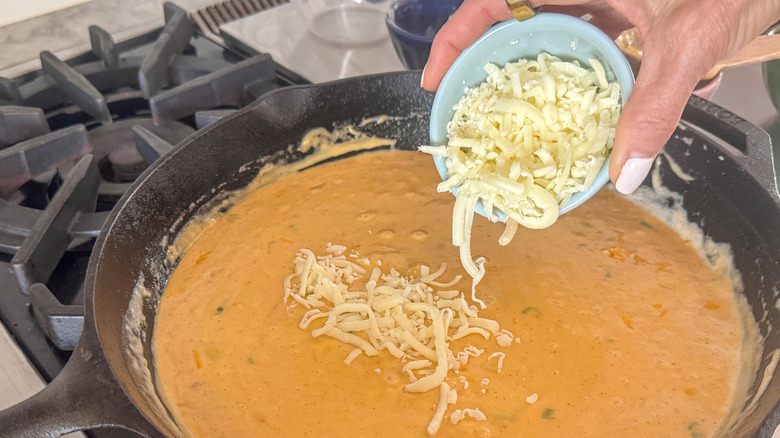 hand adding the Oaxaca cheese