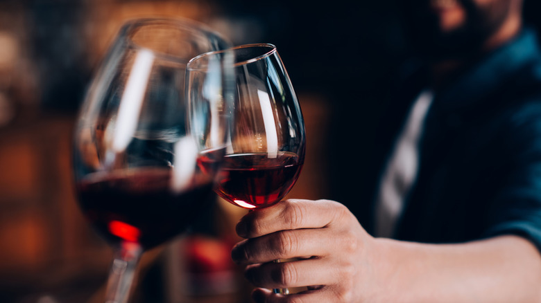 Clinking glasses of red wine