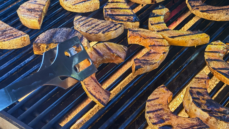 flipping grilled squash on a grill