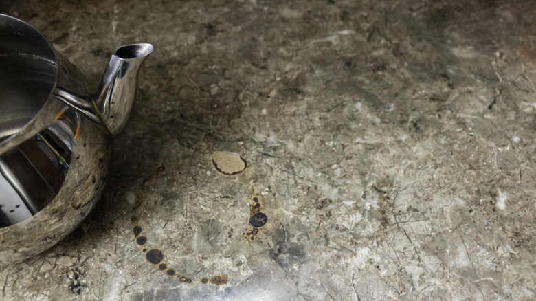 Scorched laminate countertop surface next to a kettle