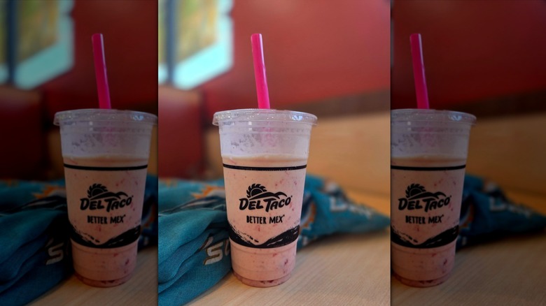 Del Taco Strawberry Shake with straw on table