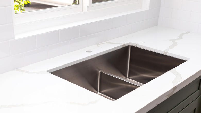 White quartz countertop around kitchen sink.