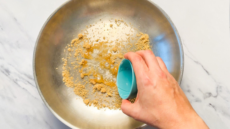 Adding water to pan with sugar