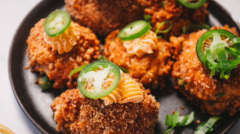Close up on crab cake jalapeño popper bites on a white platter