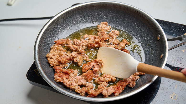 crumbling sausage in a skillet
