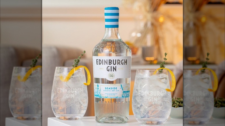 A bottle of Edinburgh Gin Seaside beside two cocktails.
