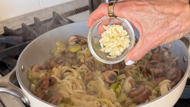 hand adding garlic