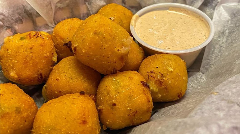Rattlesnake Bites from Texas Roadhouse in a paper lined basket with some sauce