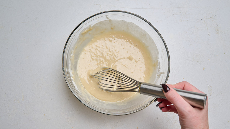 whisking wet ingredients into dry batter