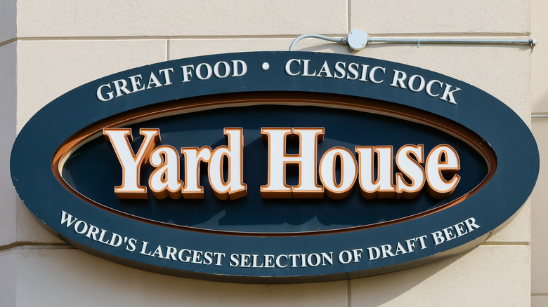 Sign outside Yard House promoting food, rock, and its extensive draft beer selection