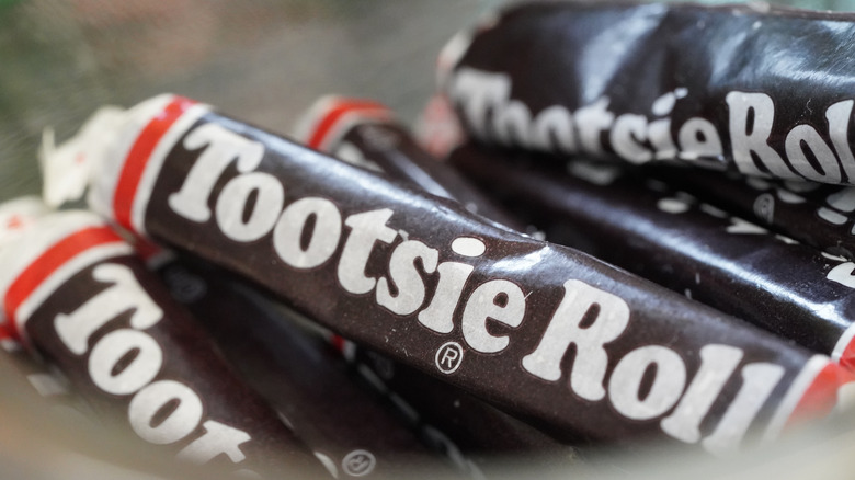 A close up of a jar of Tootsie Rolls